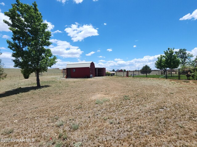 view of yard featuring a rural view and an outdoor structure