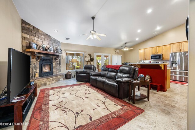 living room with ceiling fan, french doors, a fireplace, and vaulted ceiling