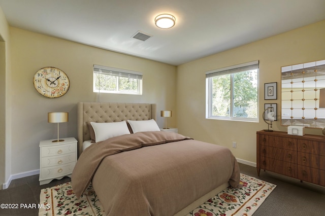 bedroom featuring visible vents, dark carpet, and baseboards