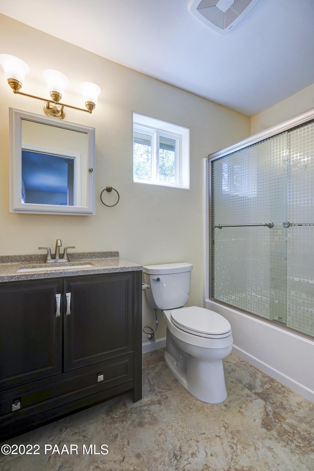 bathroom with toilet, visible vents, combined bath / shower with glass door, and vanity