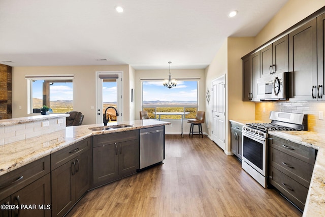 kitchen featuring decorative light fixtures, sink, stainless steel appliances, and plenty of natural light