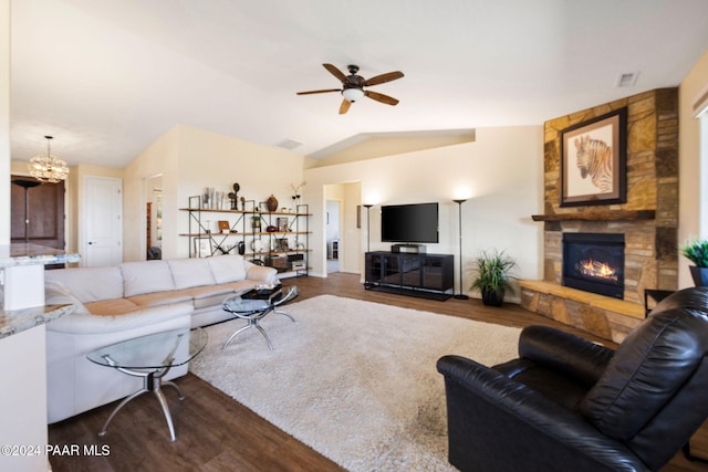 living room featuring dark hardwood / wood-style floors, lofted ceiling, a fireplace, and ceiling fan with notable chandelier