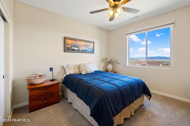 carpeted bedroom with ceiling fan and a closet