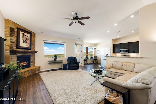 living room with a fireplace, dark hardwood / wood-style flooring, ceiling fan with notable chandelier, and lofted ceiling