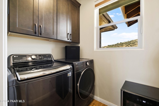 washroom featuring washer and clothes dryer, cabinets, and hardwood / wood-style flooring