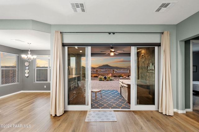 entryway featuring light hardwood / wood-style flooring and ceiling fan with notable chandelier