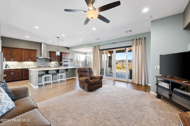 living room with light hardwood / wood-style flooring, ceiling fan, and sink