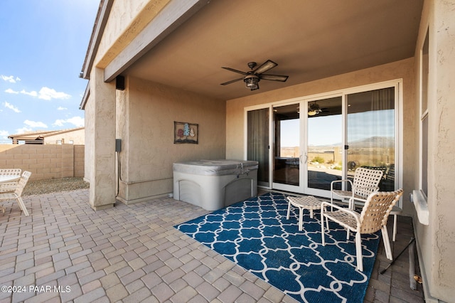 view of patio / terrace with ceiling fan, a hot tub, and french doors