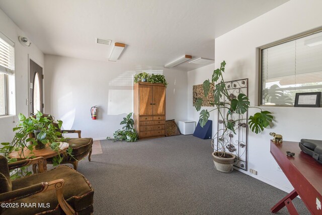 unfurnished living room with baseboards, visible vents, ceiling fan with notable chandelier, and dark wood-type flooring