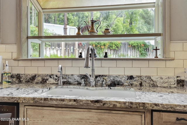 room details featuring light stone countertops and sink