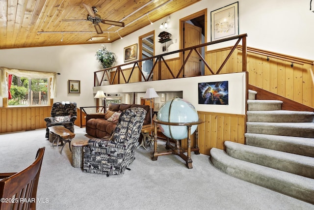 carpeted living room featuring wooden walls, wooden ceiling, ceiling fan, and vaulted ceiling