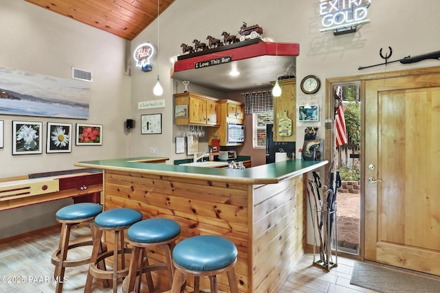 bar featuring sink, wooden ceiling, and high vaulted ceiling