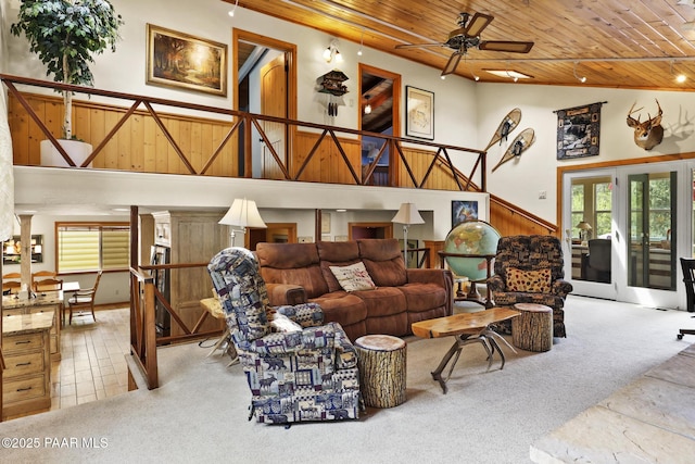 living room featuring french doors, wood walls, wood ceiling, light carpet, and ceiling fan