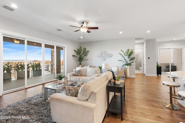 living room featuring recessed lighting, visible vents, and light wood finished floors