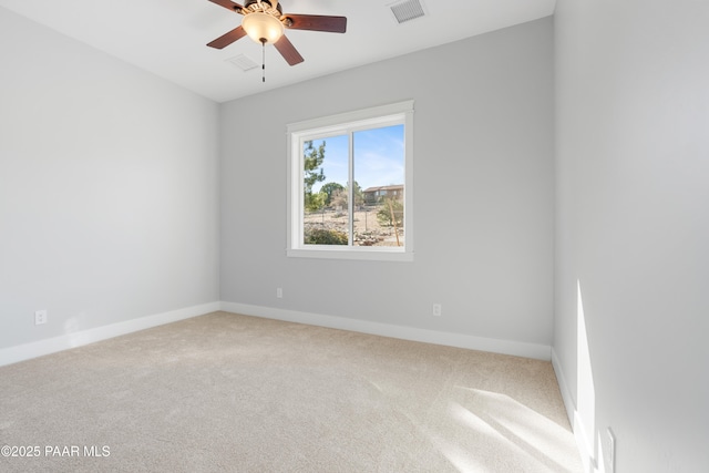 carpeted spare room featuring baseboards, visible vents, and ceiling fan