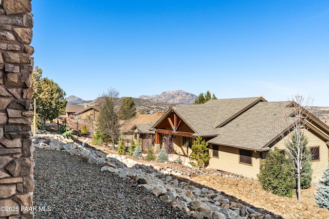 craftsman-style home with a mountain view and a shingled roof