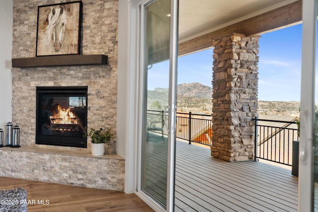 balcony featuring a mountain view and an outdoor stone fireplace