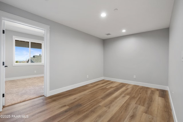 empty room with recessed lighting, visible vents, baseboards, and light wood finished floors