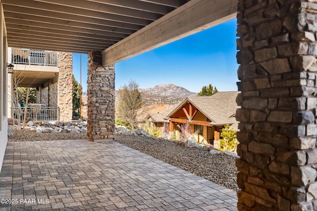 view of patio with a mountain view and a balcony