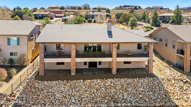 rear view of property featuring a residential view, a tiled roof, a patio, and fence