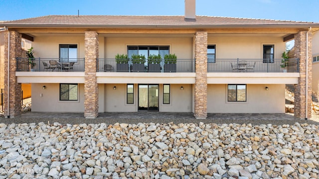 rear view of house with stucco siding and a patio