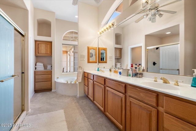 bathroom featuring double vanity, a sink, a bath, and a shower stall