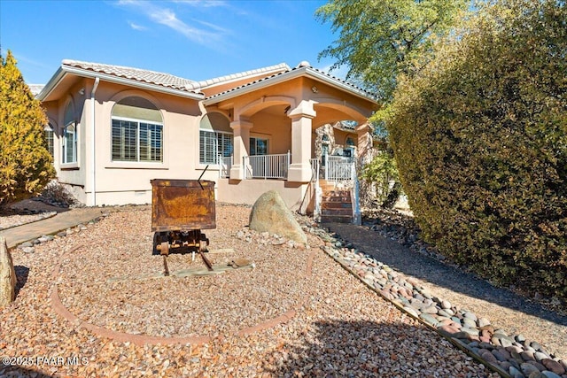 back of property featuring covered porch, crawl space, a tile roof, and stucco siding