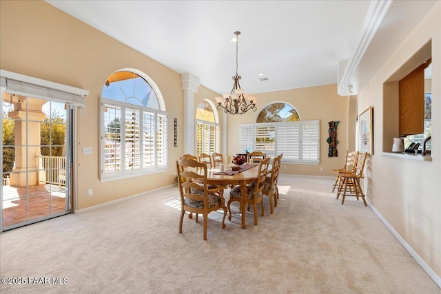 dining room featuring ornate columns, baseboards, a chandelier, and carpet flooring