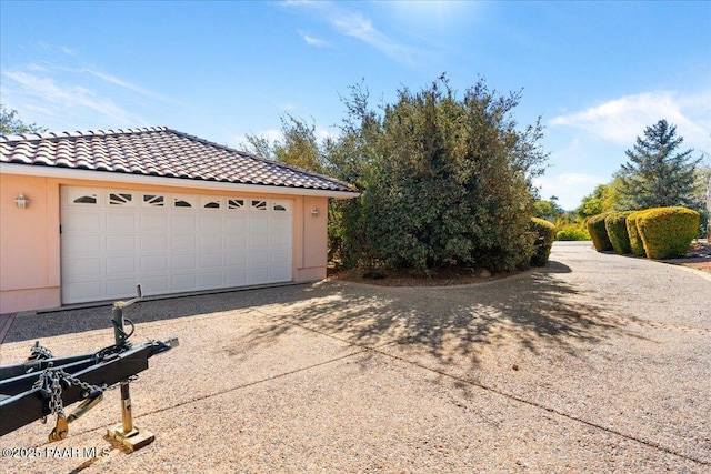 view of front of home with a garage, stucco siding, and a tiled roof