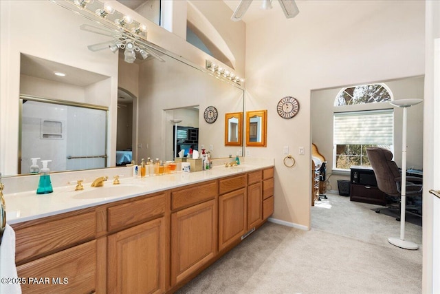 bathroom with ceiling fan, double vanity, ensuite bath, and a sink