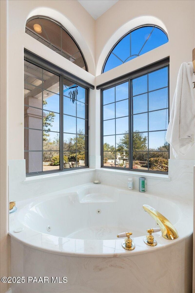 full bathroom with a tub with jets