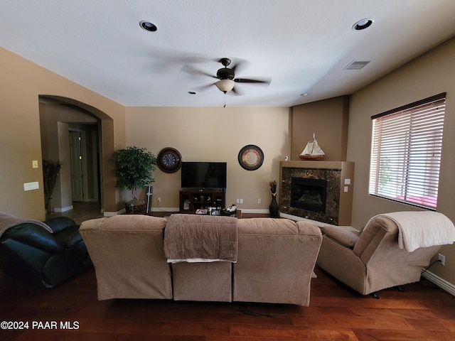 living room with dark hardwood / wood-style floors, ceiling fan, and a fireplace