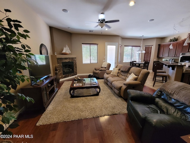 living room with ceiling fan, dark wood-type flooring, and a premium fireplace