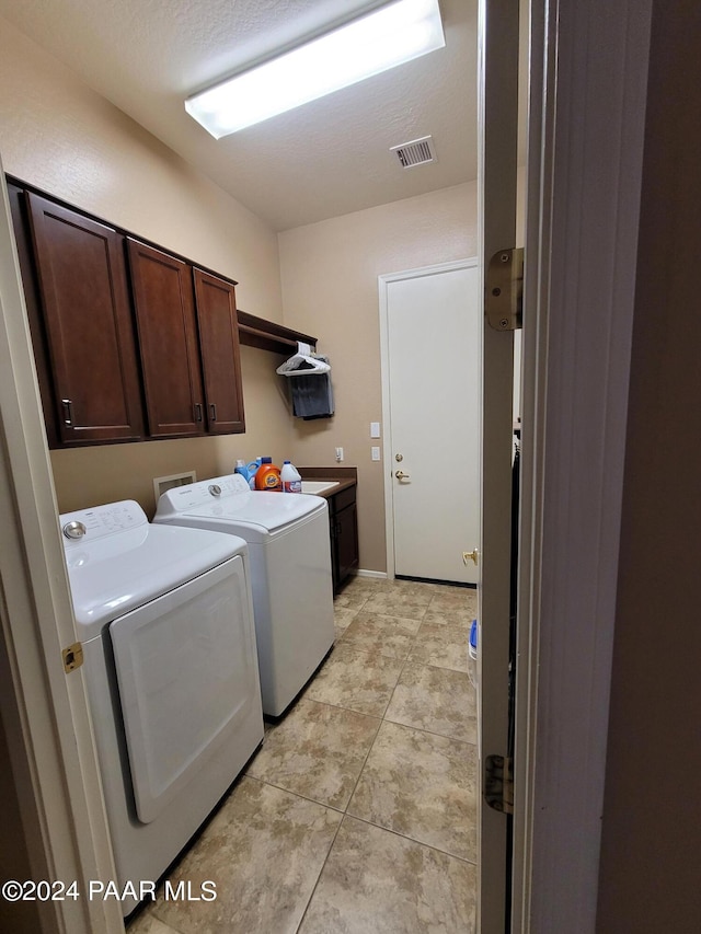 laundry room with cabinets, independent washer and dryer, and sink