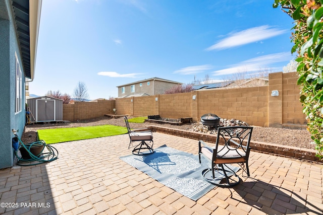 view of patio / terrace featuring a fenced backyard, a shed, and an outdoor structure
