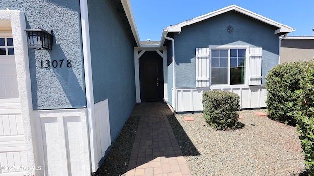 entrance to property with stucco siding