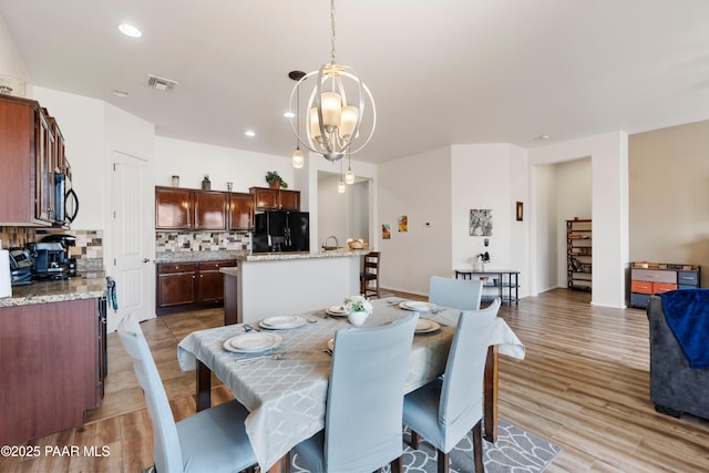 dining room featuring visible vents, a notable chandelier, light wood-style flooring, and recessed lighting