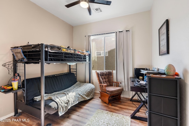 bedroom with wood finished floors, visible vents, ceiling fan, and baseboards