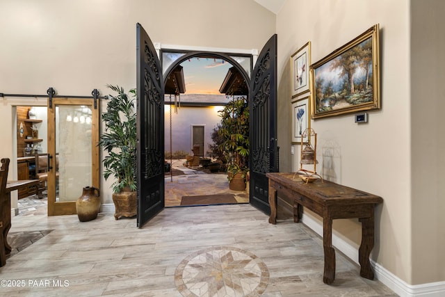 entryway featuring french doors, light hardwood / wood-style floors, and a barn door