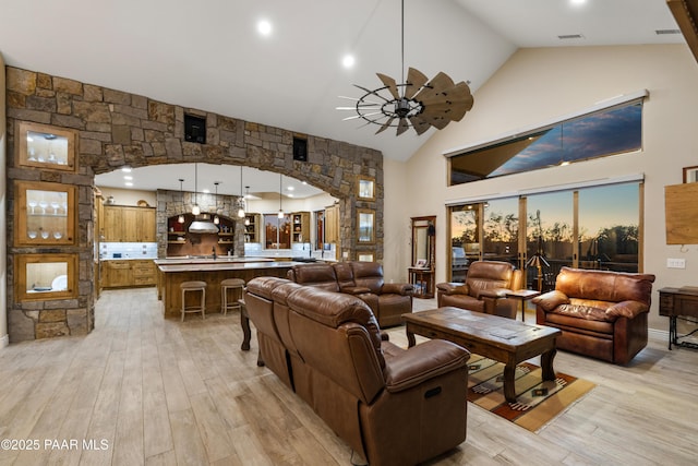 living room featuring high vaulted ceiling, ceiling fan, and light hardwood / wood-style floors