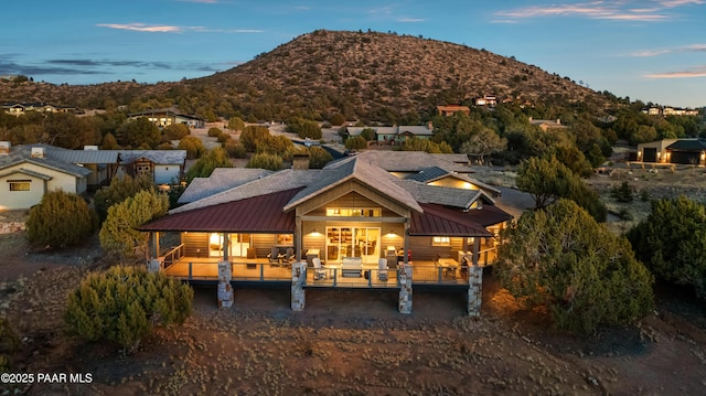 back house at dusk featuring outdoor lounge area and a mountain view