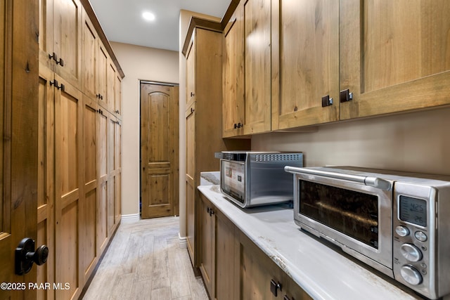 clothes washing area with light hardwood / wood-style floors