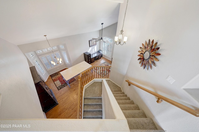 stairs featuring high vaulted ceiling and a chandelier