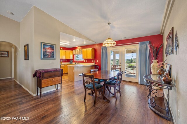 9341 E Manzanita Cir, Prescott Valley, AZ 86314 - dining space featuring dark wood-style flooring, arched walkways, a chandelier, french doors, and vaulted ceiling