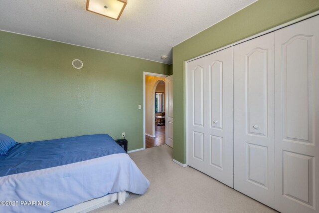 9341 E Manzanita Cir, Prescott Valley, AZ 86314 - carpeted bedroom with arched walkways, baseboards, and a closet