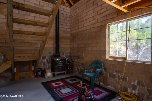 unfurnished living room with a wood stove and concrete floors