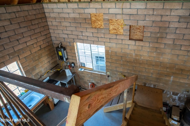 unfurnished living room with brick wall