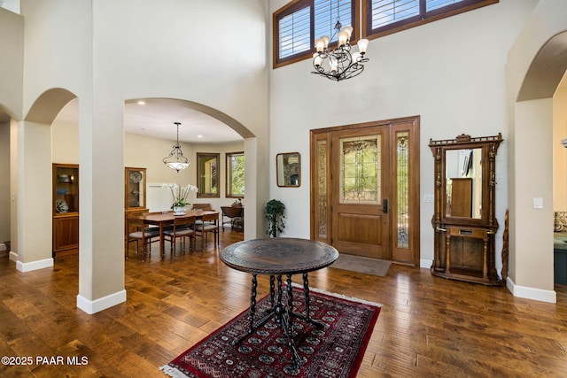 2469 W Post Oak Dr, Prescott, AZ 86305 - entryway featuring a high ceiling, plenty of natural light, arched walkways, dark wood-type flooring, and a chandelier