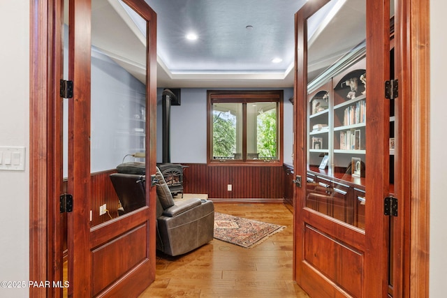 2469 W Post Oak Dr, Prescott, AZ 86305 - home office featuring a wood stove, light wood-style flooring, a wainscoted wall, wood walls, and a tray ceiling