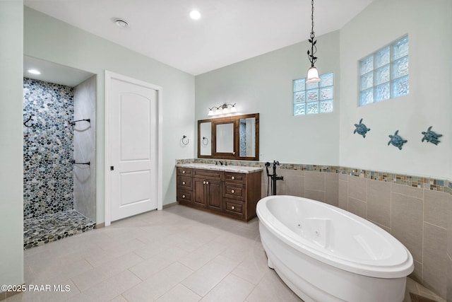 2469 W Post Oak Dr, Prescott, AZ 86305 - bathroom with a tub with jets, a walk in shower, vanity, tile walls, and tile patterned floors